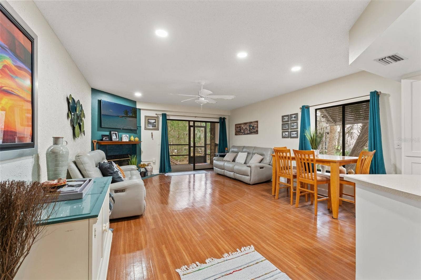 5155 S GRAY PELICAN WAY, Homosassa, FL 34448 Living Room + Dining Room. There is a wood-burning fireplace in the living room and a screened-in porch.