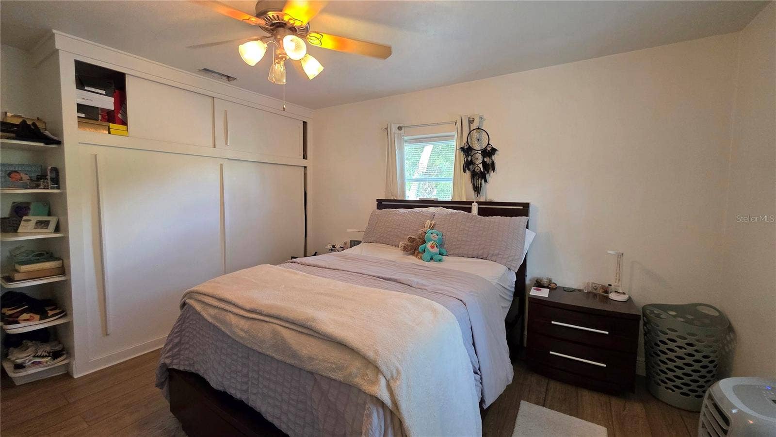 1702 26TH STREET W, Bradenton, FL 34205 Primary Bedroom, Decorative Shelving, Ceiling Fan, Laminate Flooring, Window overlooking Front Yard