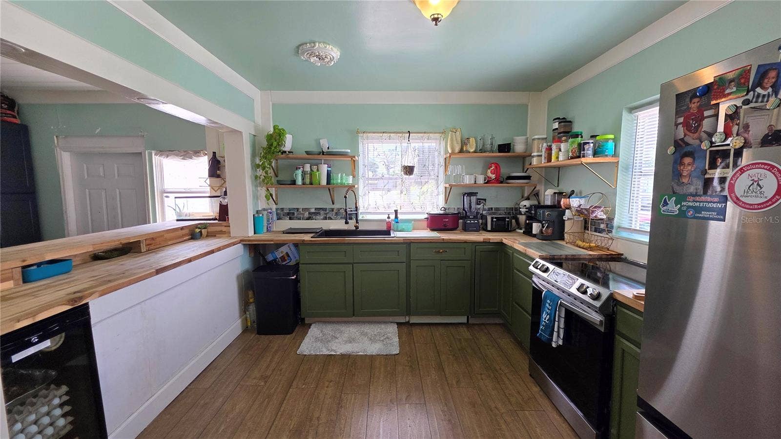 1702 26TH STREET W, Bradenton, FL 34205 Kitchen with Butcher Block Countertops, Stainless appliances, Decorative Shelving, 2 Windows, and Laminate Flooring