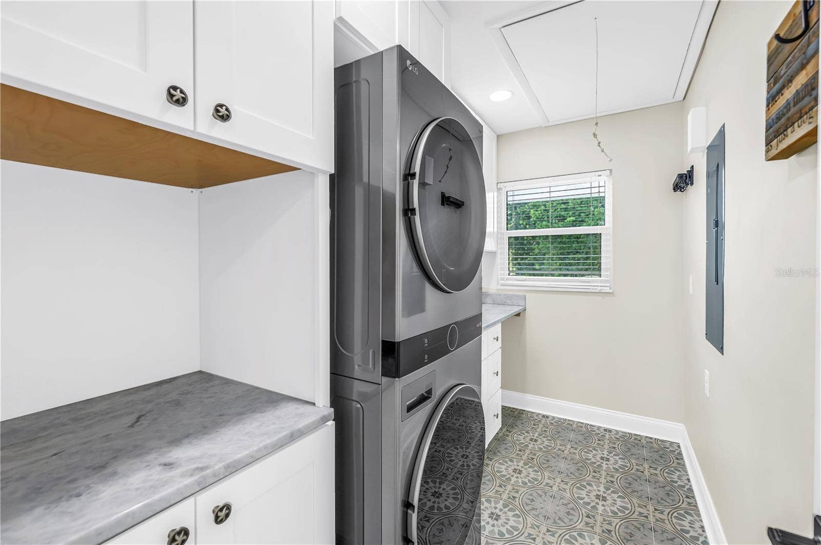 1114 2ND AVENUE S, Tierra Verde, FL 33715 Oversized laundry room with Shaker cabinetry, quartz countertops (all match kitchen), utility sink, storage and FULL size stackable LG ThinQ high efficiency washer and dryer.