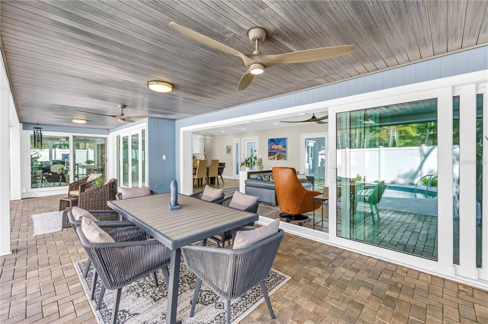 1114 2ND AVENUE S, Tierra Verde, FL 33715 impact-rated pocket sliders disappear completely into the wall, dramatically opening the living room to the lanai and pool