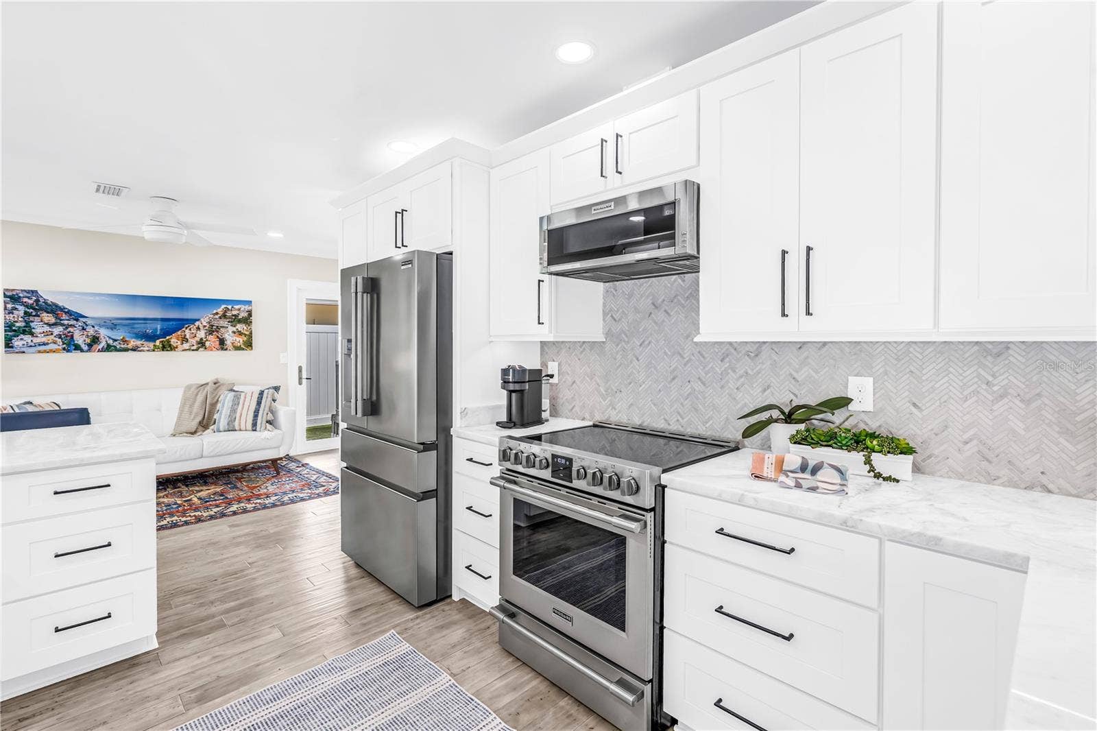 1114 2ND AVENUE S, Tierra Verde, FL 33715 Stainless appliances, range with convection and air fryer functions, deep storage drawers and a herringbone shell tile backsplash.