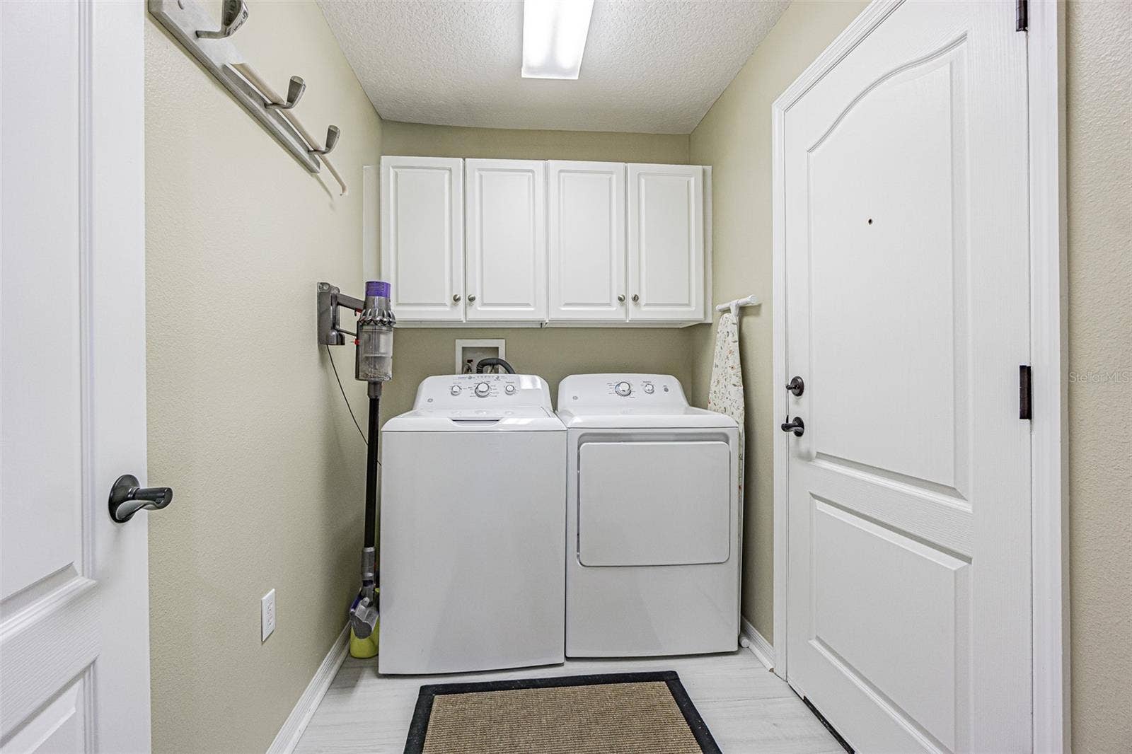 Interior laundry room with storage cabinets above