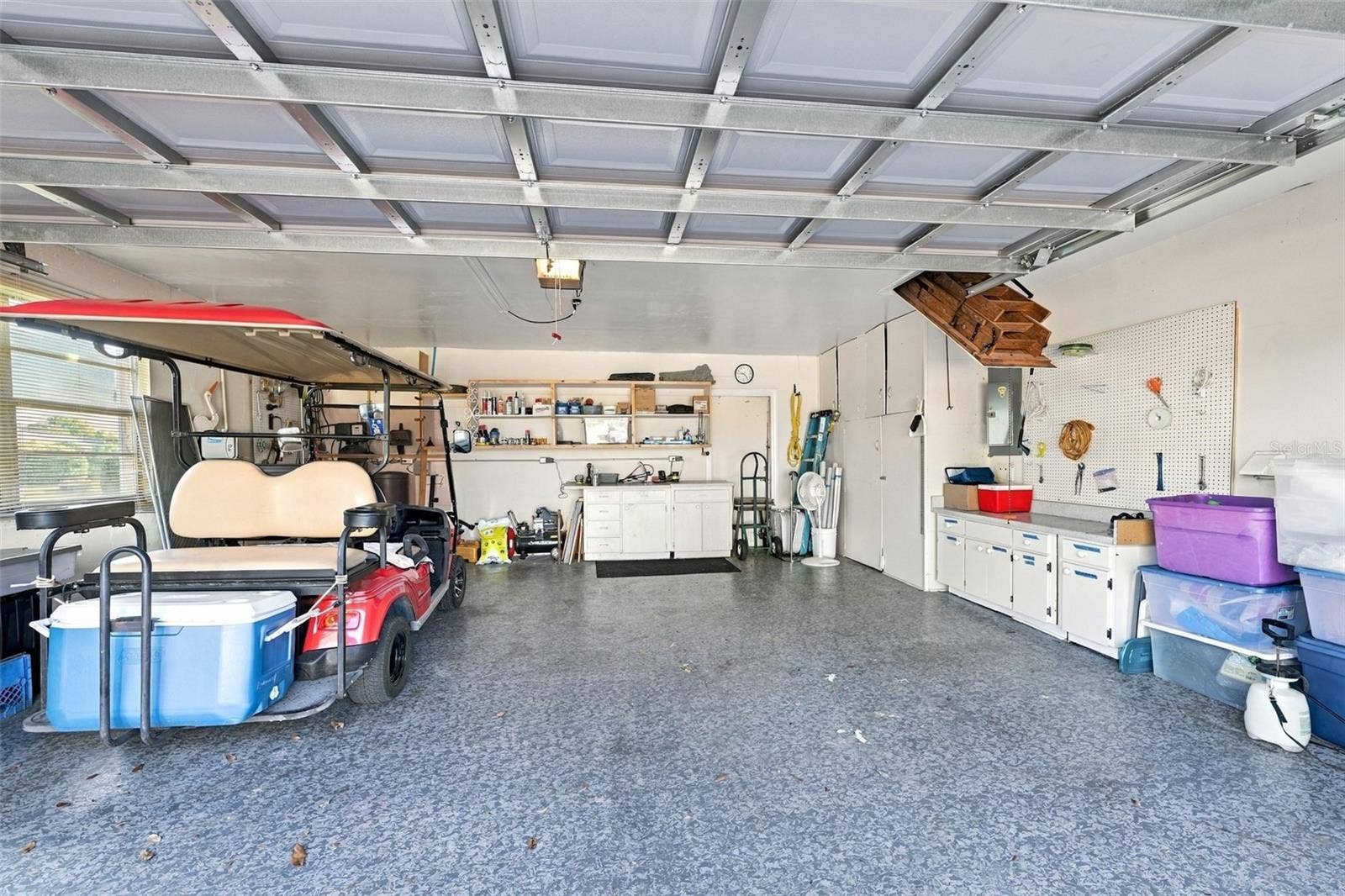 211 STONEHAM DRIVE, Sun City Center, FL 33573 The garage is oversized, with epoxy flooring, storage cabinets and YES, the golf cart is included. Notice the attic stairs offer full storage capability, if desired.