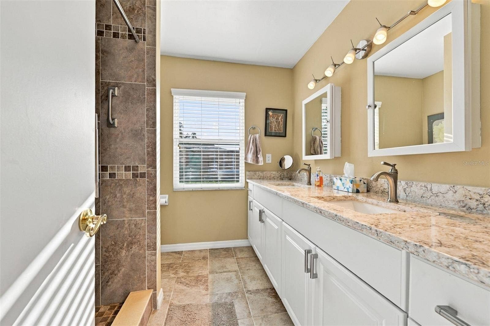 211 STONEHAM DRIVE, Sun City Center, FL 33573 Guest bathroom is updated and modern with dual sinks, cabinetry and lovely tile work.