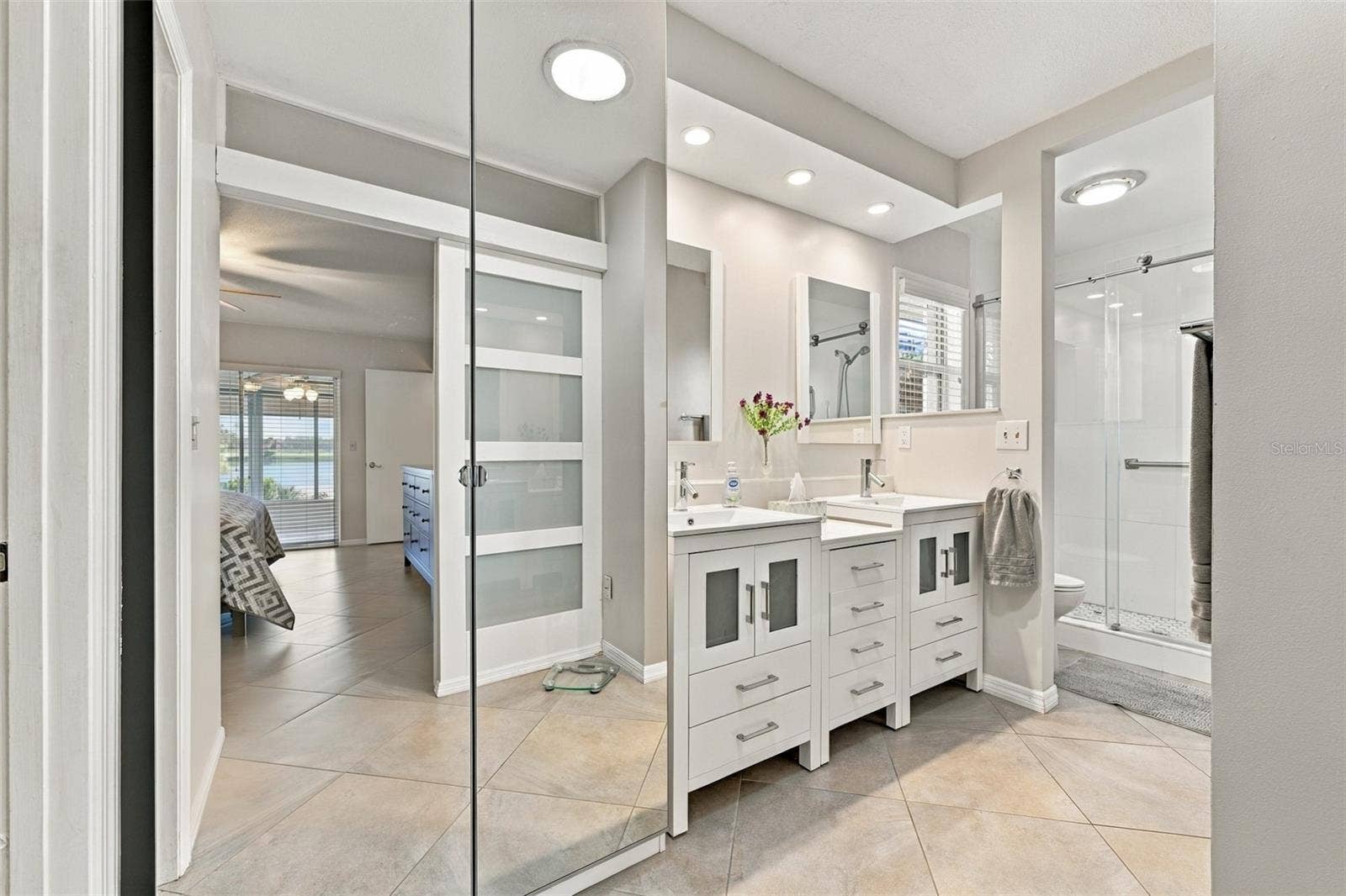 211 STONEHAM DRIVE, Sun City Center, FL 33573 Stunning ensuite bathroom with dual sinks, updated shower and modern fistures.