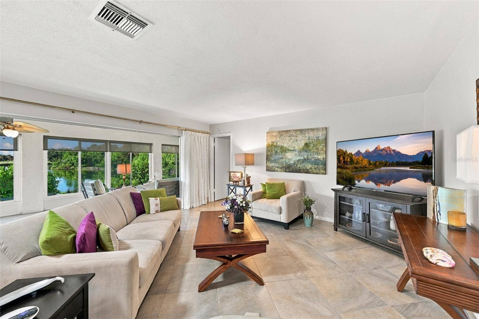 211 STONEHAM DRIVE, Sun City Center, FL 33573 The great room opens right onto the Florida room, which has a wall of windows and sun shades.