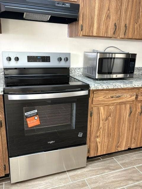 2102 HARRINGAY STREET, #449, Sun City Center, FL 33573 Whirlpool range with hood.