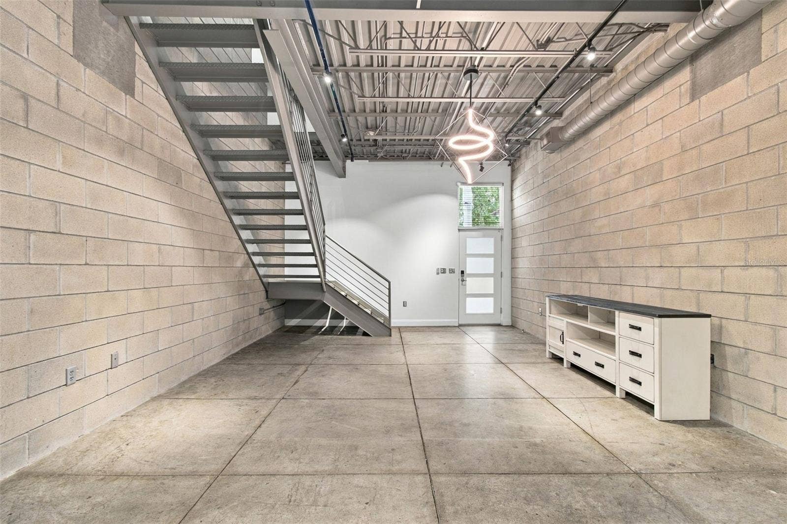 2509 W AZEELE STREET, Tampa, FL 33609 Industrial-style loft features concrete block walls and concrete flooring.