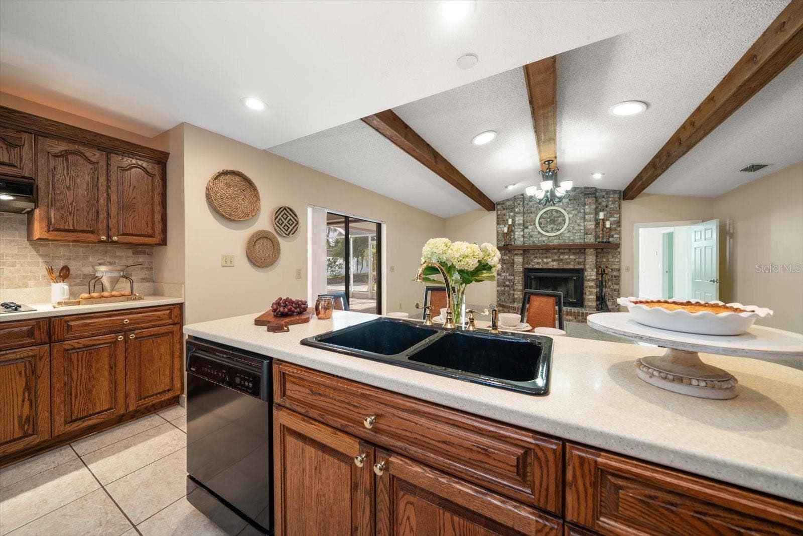 1105 DEER RUN PLACE, Valrico, FL 33594 Warm and inviting great room with kitchen, eating and family room with masonry fireplace and beamed ceiling!