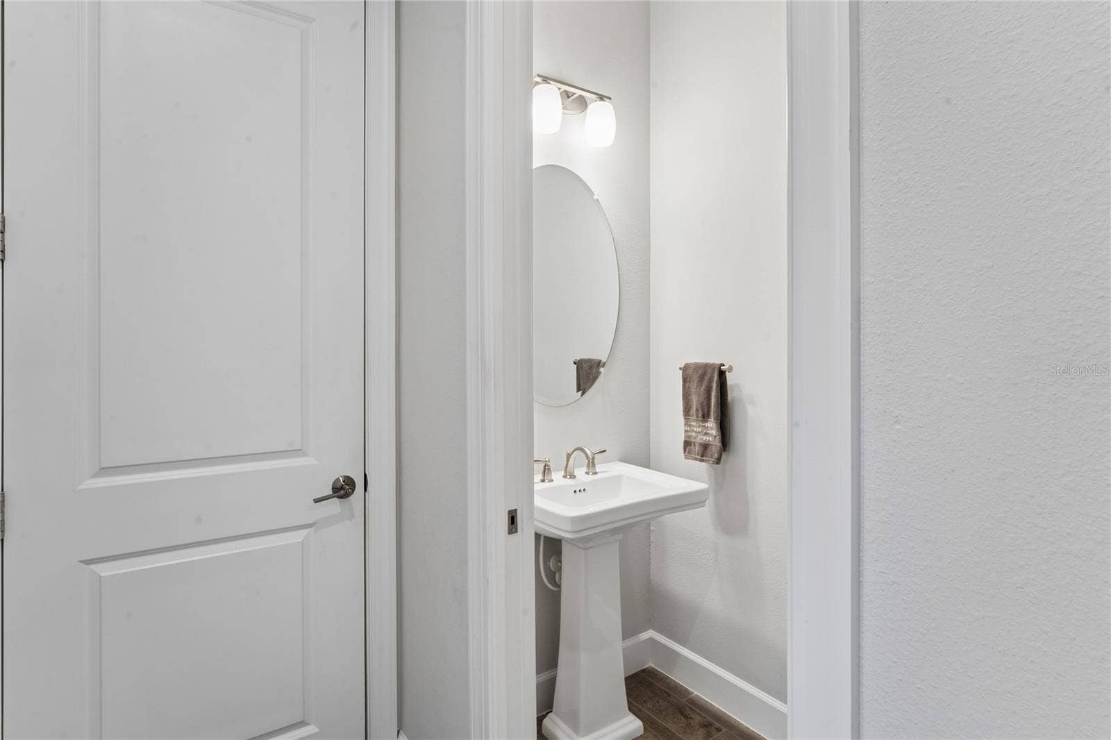 Half bath in hallway leading out to garage