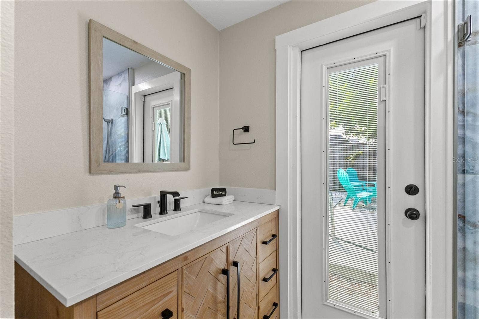 201 SOUTH STREET, Palm Harbor, FL 34683 Updated vanity with modern black fixtures and direct exterior accessespecially convenient when enjoying the pool.