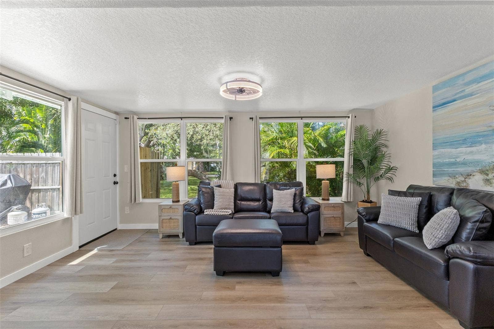 201 SOUTH STREET, Palm Harbor, FL 34683 A wall of windows fills the room with natural light while overlooking the surrounding tropical landscaping.