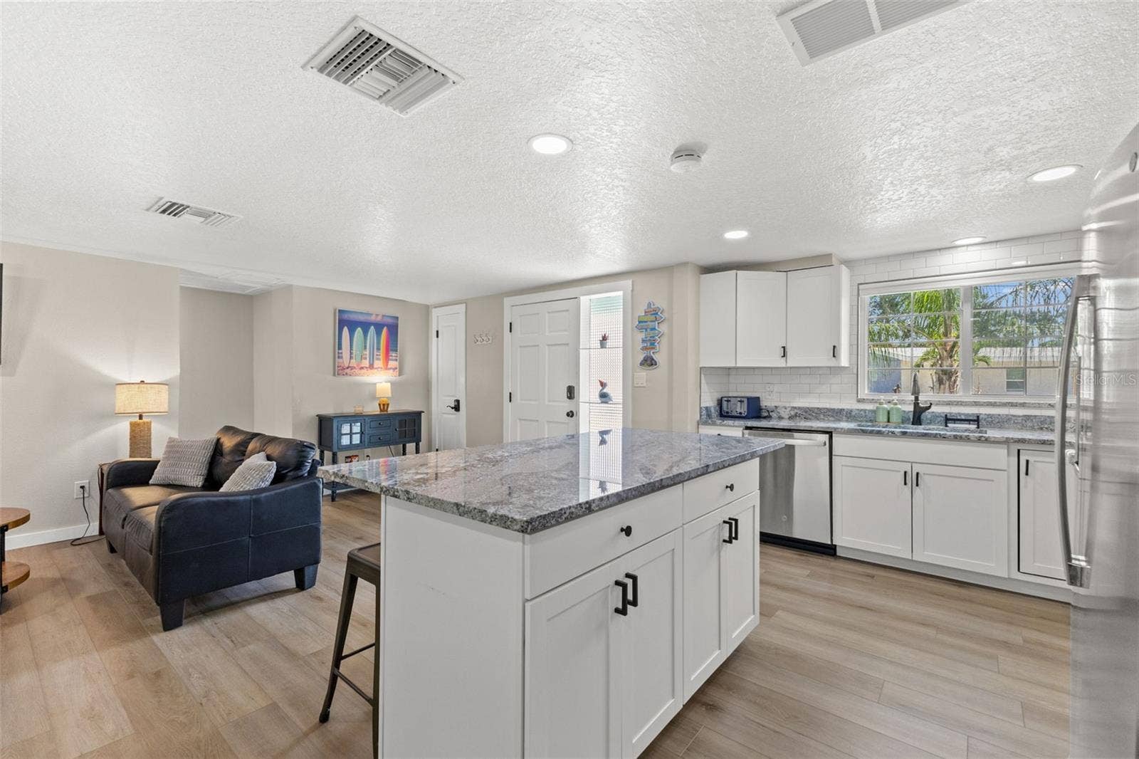 201 SOUTH STREET, Palm Harbor, FL 34683 Generous granite-topped island adds abundant prep space, storage, and casual seating to the renovated kitchen.