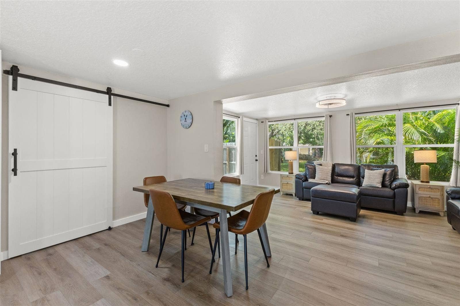 201 SOUTH STREET, Palm Harbor, FL 34683 Dedicated dining area sits between the renovated kitchen and living spaces, with a large barn door adding character and function.