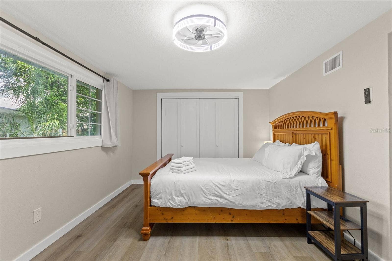 201 SOUTH STREET, Palm Harbor, FL 34683 Bright secondary bedroom with luxury vinyl plank flooring, a large window, and ample closet storage.