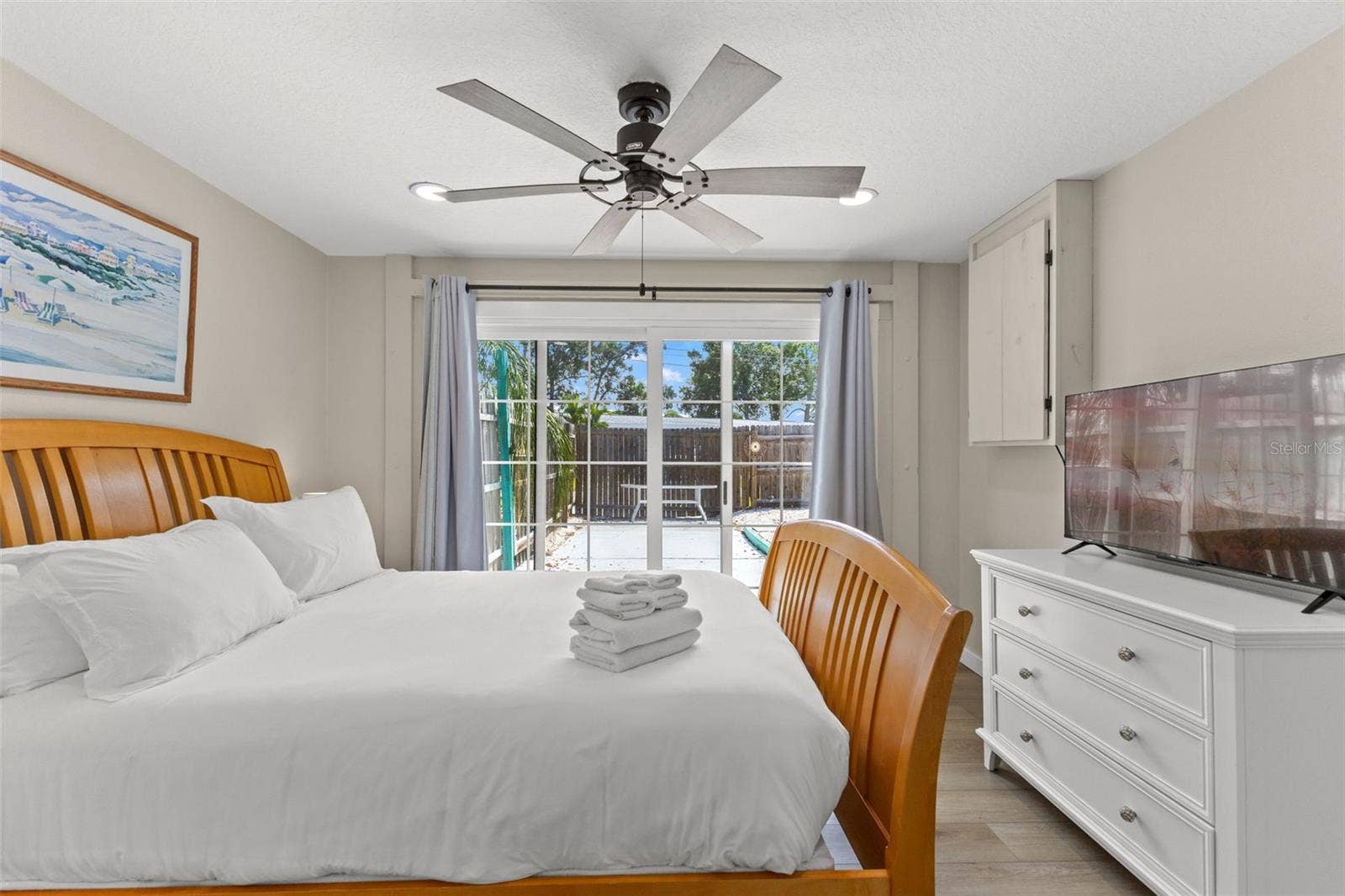 201 SOUTH STREET, Palm Harbor, FL 34683 Another view of the owner's bedroom highlights the direct pool access and abundant natural light from the oversized sliding glass doors.