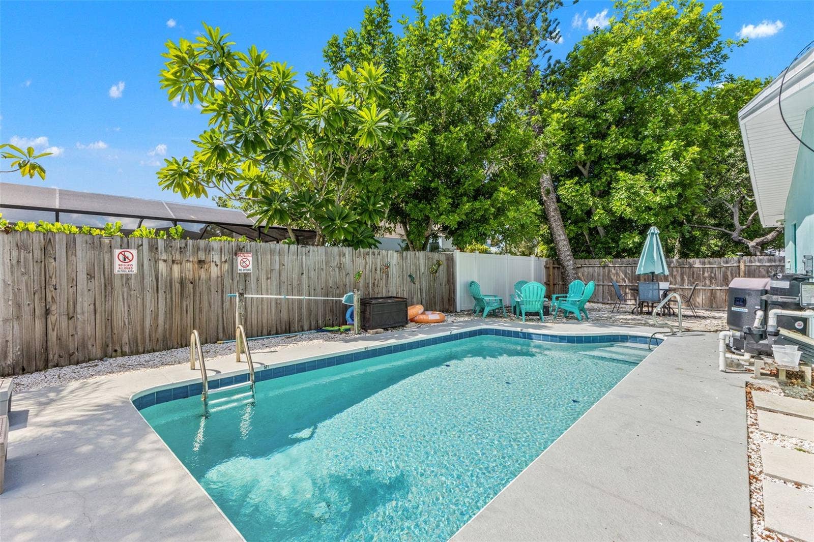 201 SOUTH STREET, Palm Harbor, FL 34683 Private heated pool surrounded by mature landscaping and multiple spaces for lounging and relaxing outdoors.