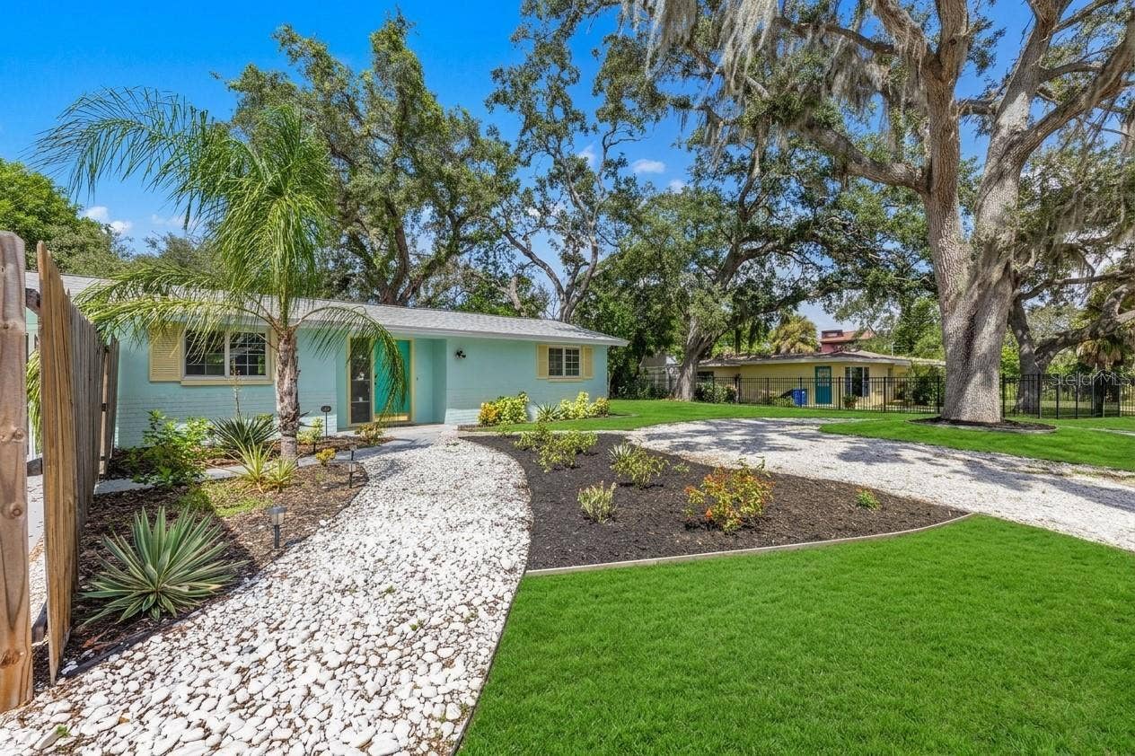 201 SOUTH STREET, Palm Harbor, FL 34683 Wide view highlights the homes spacious .19-acre lot, mature shade trees, tropical landscaping, and generous outdoor space.