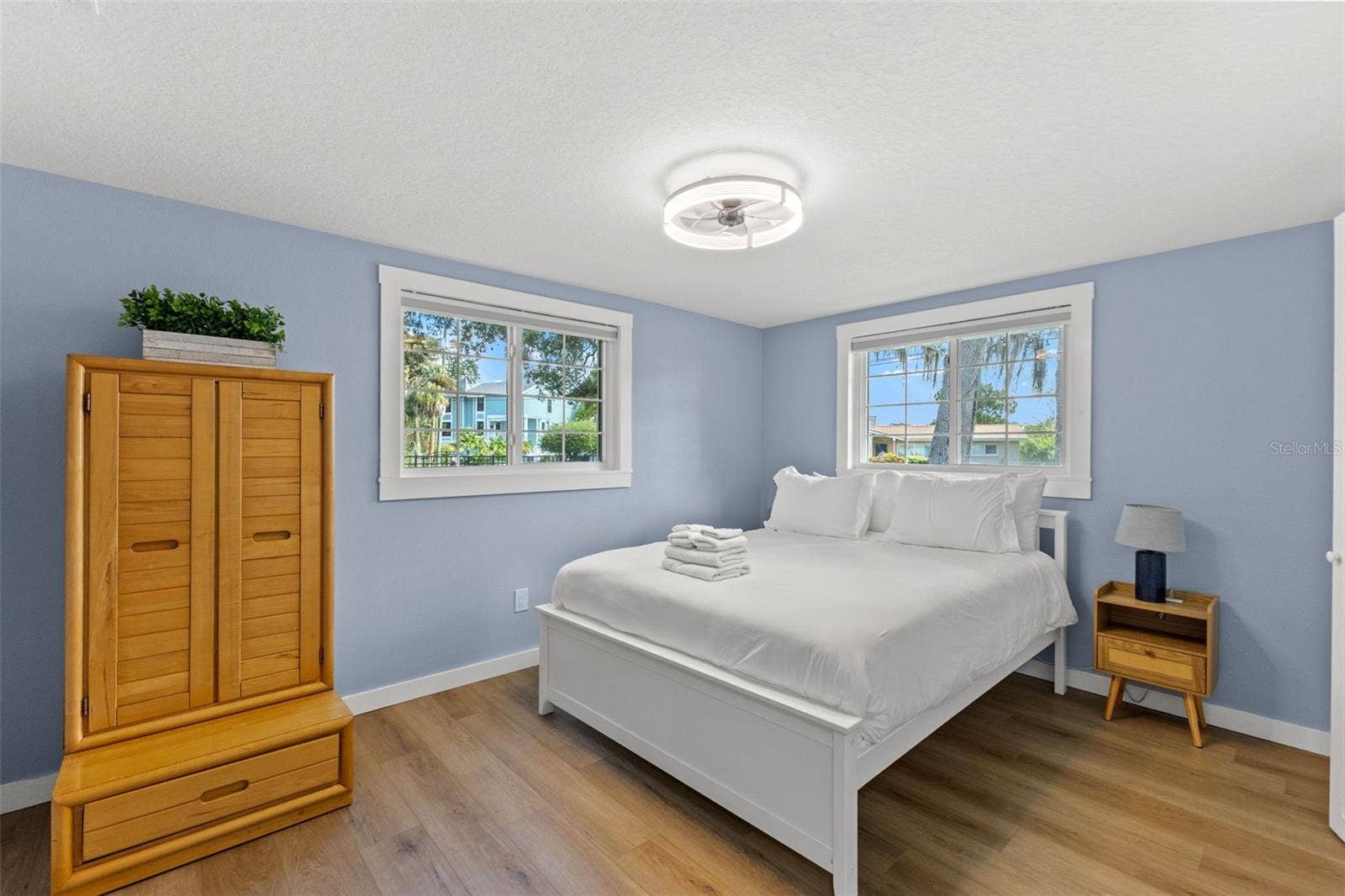 201 SOUTH STREET, Palm Harbor, FL 34683 Bright bedroom with luxury vinyl plank flooring, two windows, and updated trim.