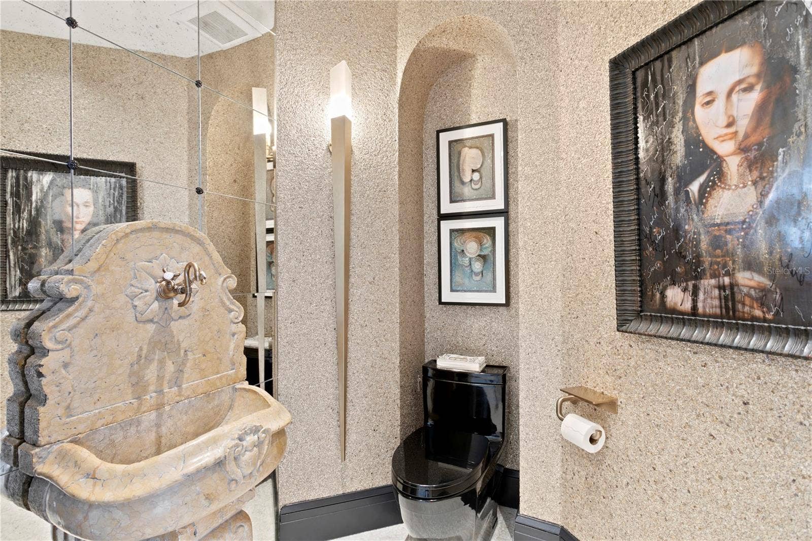 The sink from the converted French fountain offers a unique experience in the powder bathroom