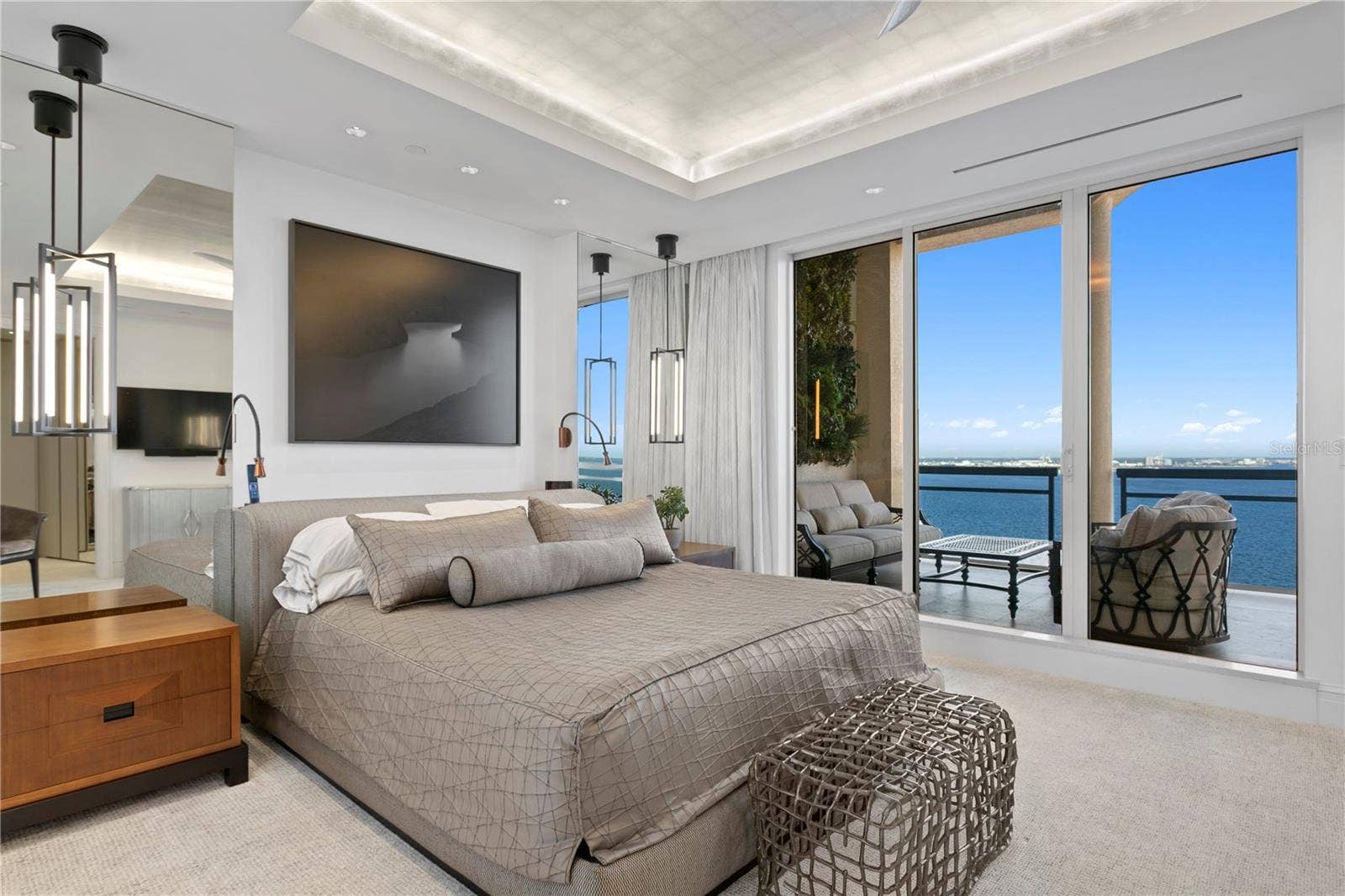Primary Suite Bedroom with captivating water views, lighting pads for each bedside, and auto close curtains