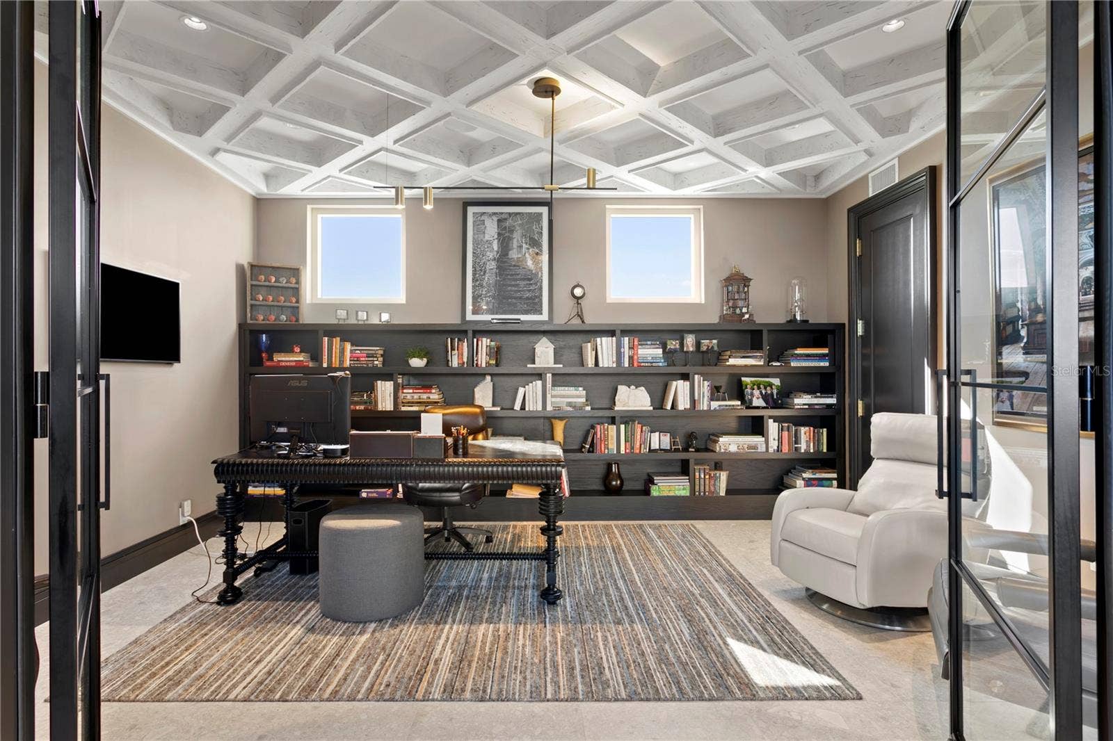 In-home office with glass wall and French doors.  The view from the the desk is all water