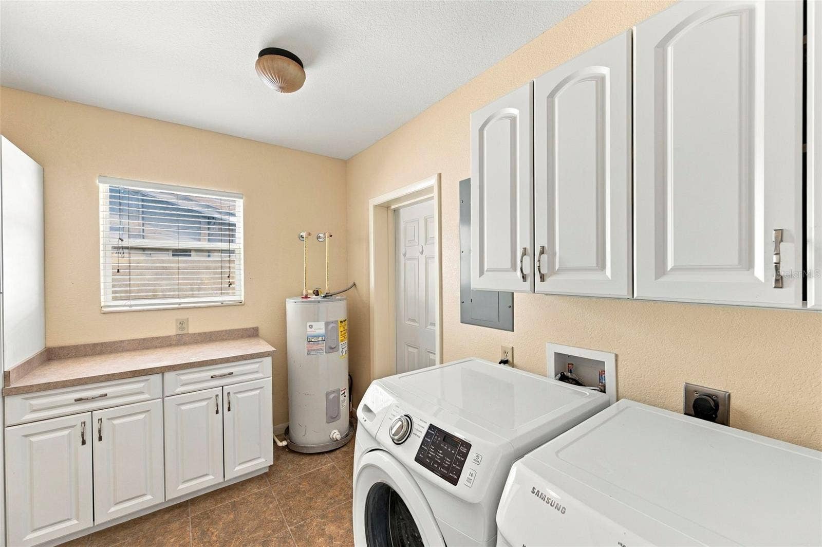 Laundry Room with ample storage space and access to the backyard