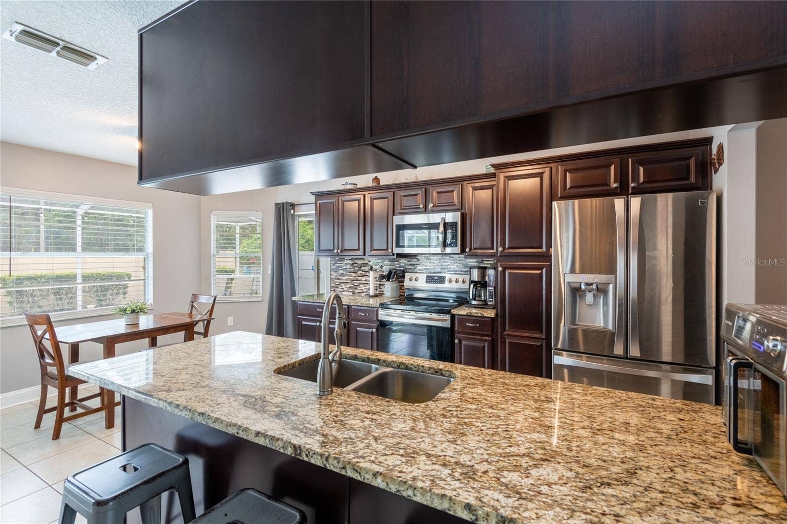 9713 LOMALINDA COURT, New Port Richey, FL 34655 Kitchen and dinette with granite counter tops and wood cabints.