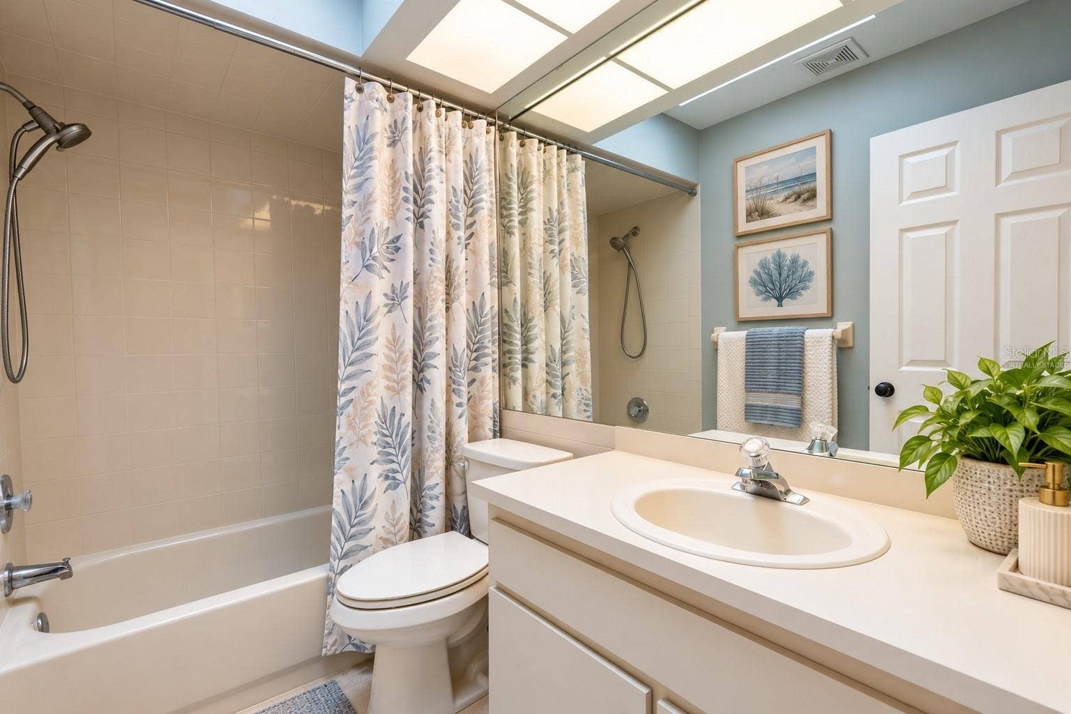 9713 LOMALINDA COURT, New Port Richey, FL 34655 Bathroom shared by second and third bedrooms with virtually staged decor.