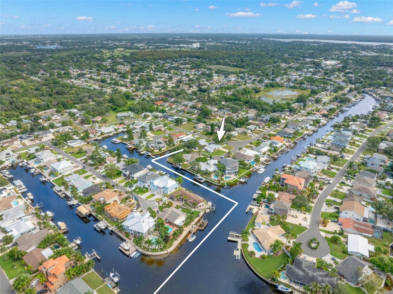 A dramatic aerial view captures Baywood Villages interconnected canal system and the boating lifestyle that defines the neighborhood, with waterfront homes, private docks, and direct saltwater access throughout the community.
