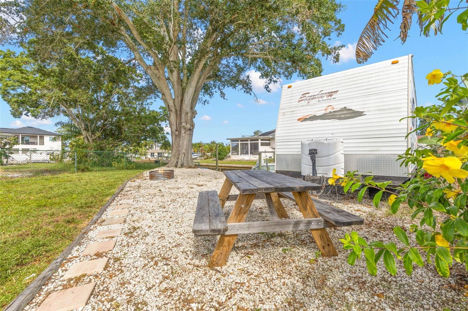 The oversized side yard offers dedicated space for RV, boat, or trailer parking, along with a gravel picnic area beneath a mature shade treeanother benefit of this generous 11,800-square-foot property.