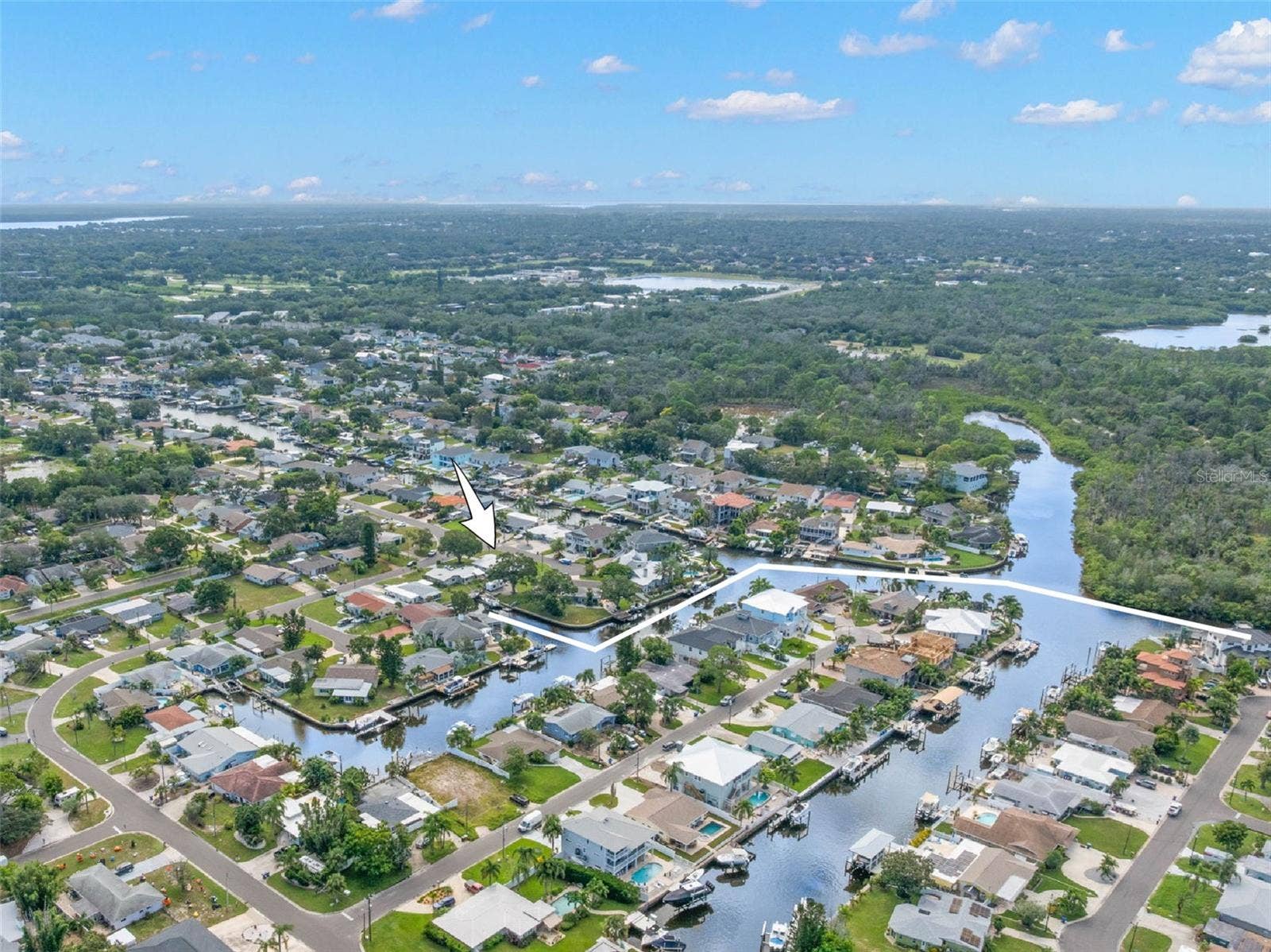 An aerial view showcases Baywood Villages network of saltwater canals and the homes close-to-the-water setting, with direct Gulf access from the neighborhood and easy reach of Tarpon Springs, Fred Howard Park, Sunset Beach, and Wall Springs Park.