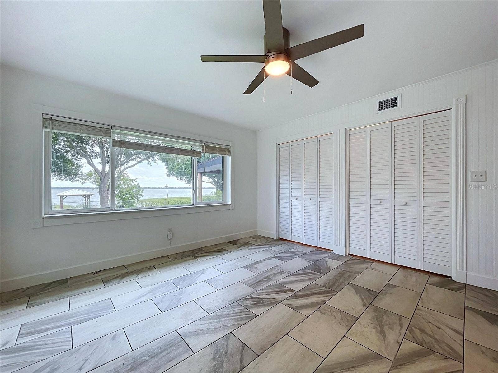 1348 EDGEWATER BEACH DRIVE, Lakeland, FL 33805 Bedroom 1 with ceiling fan and tile-pattern flooring