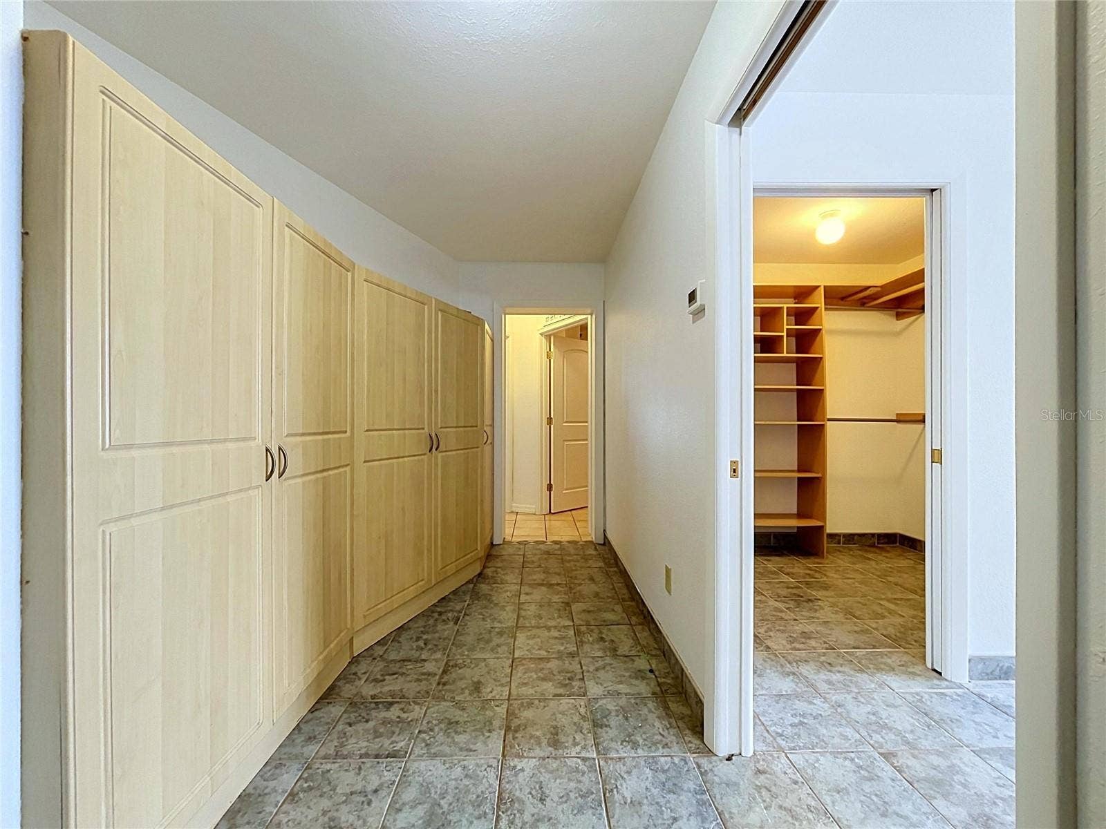 1348 EDGEWATER BEACH DRIVE, Lakeland, FL 33805 Hallway to garage and Bathroom 3 with cabinets