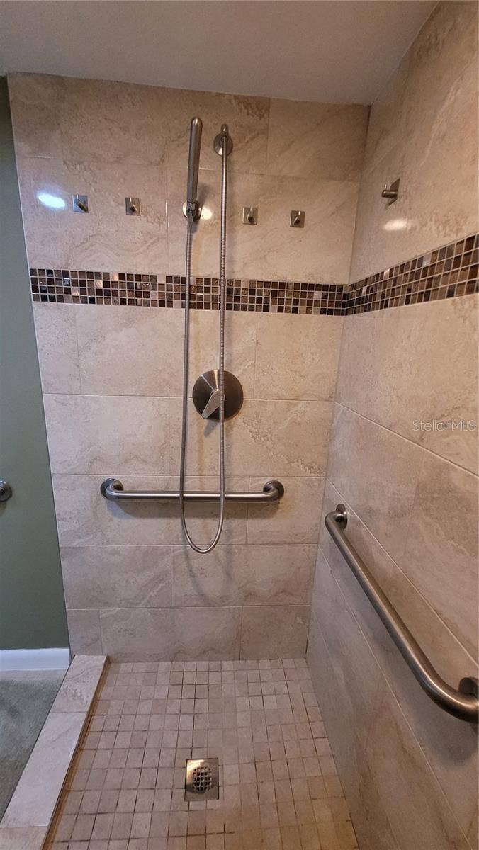 1806 MARINER DRIVE, #318, Tarpon Springs, FL 34689 The primary bath suite has a custom designed walk in tiled shower with plenty of grab bars for safety