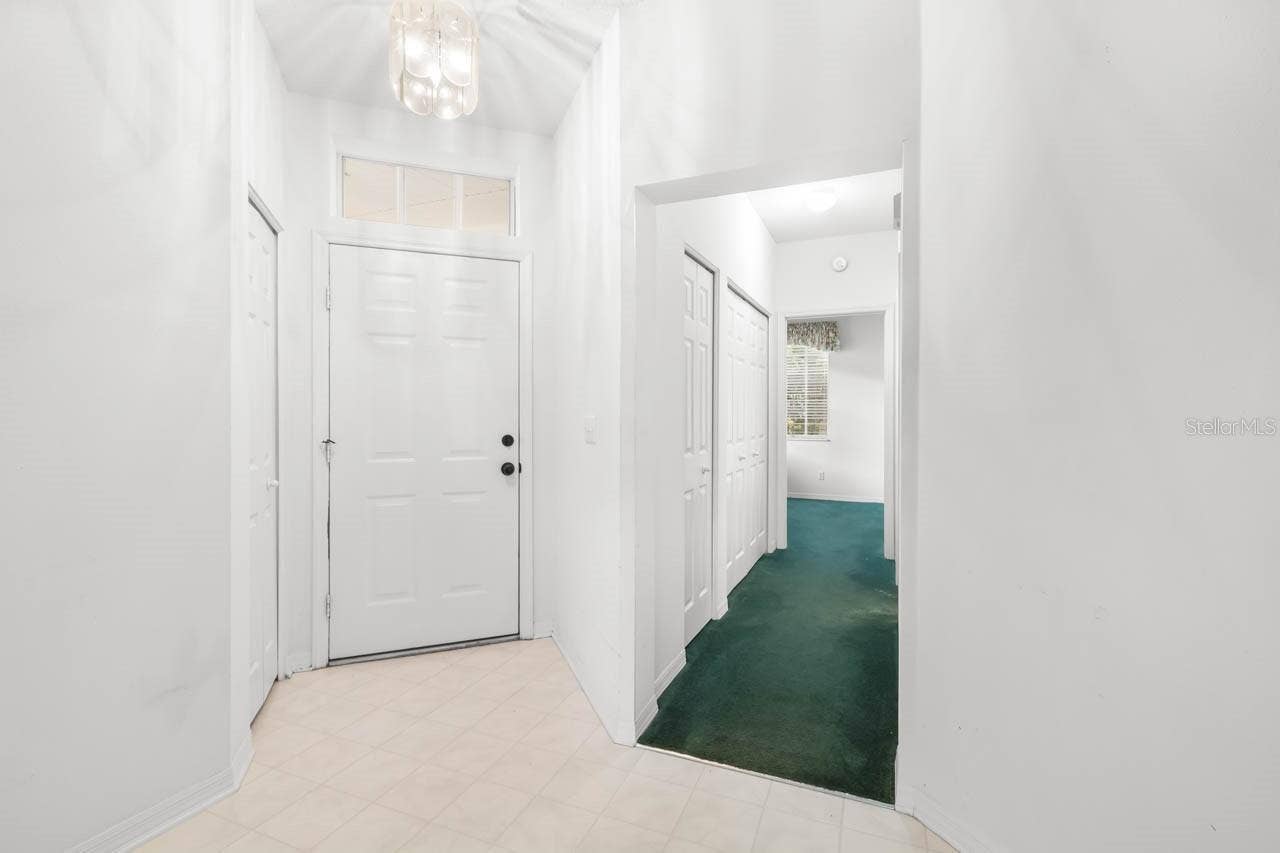 2617 NEWCOMB COURT, Sun City Center, FL 33573 Entry way from inside the front door and view of hallway to guest bath and guest bedroom