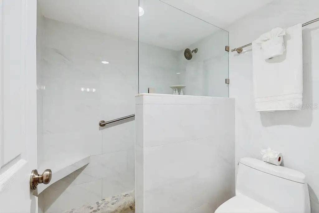18400 GULF BOULEVARD, #1208, Indian Shores, FL 33785 LARGE WALK-IN SHOWER OFF THE PRIMARY SUITE FEATURES A BUILT IN BENCH FOR ADDED COMFORT AND RELAXATION.