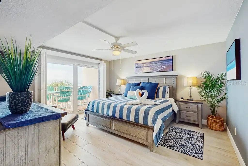 18400 GULF BOULEVARD, #1208, Indian Shores, FL 33785 SPACIOUS PRIMARY BEDROOM OFFERS PRIVATE ACCESS TO YOUR BALCONY TO ENJOY THE SOUND OF THE WAVES FROM YOUR KING SIZE BED, ALSO FEATURES PLANTATION SHUTTERS, FLAT SCREEN TV, CEILING FAN AND EN-SUITE BATHROOM.