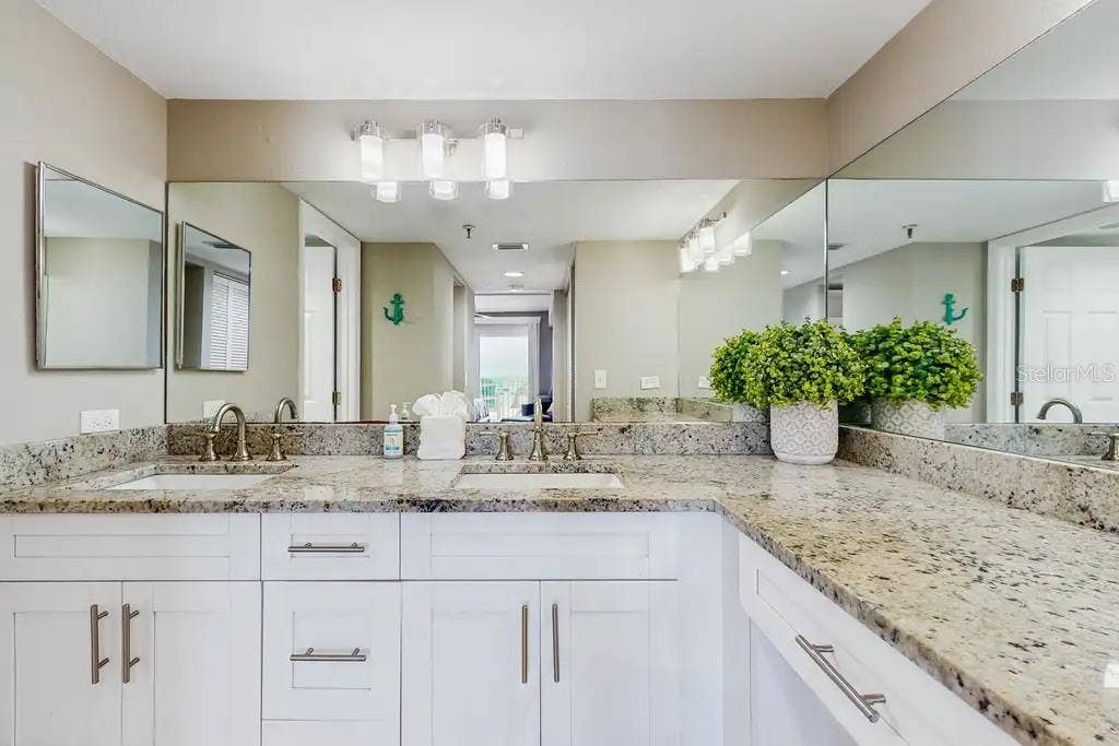 18400 GULF BOULEVARD, #1208, Indian Shores, FL 33785 EN-SUITE BATHROOM WITH SEPARATE DRESSING AREA, DOUBLE SINKS, AND LARGE WALK-IN CLOSET WITH BUILT- IN WARDROBE ORGANIZERS COMPLETES THE SPACIOUS PRIMARY SUITE.