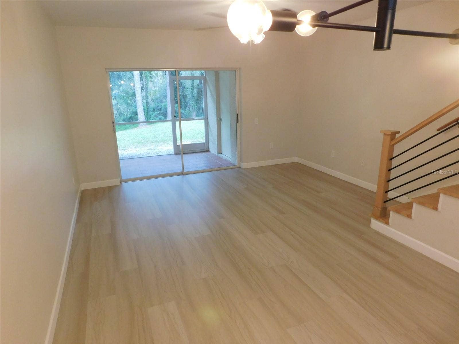 8660 HUNTERS KEY CIRCLE, Tampa, FL 33647 Living Area features new modern LVP and new Wood stairs for a modern finish