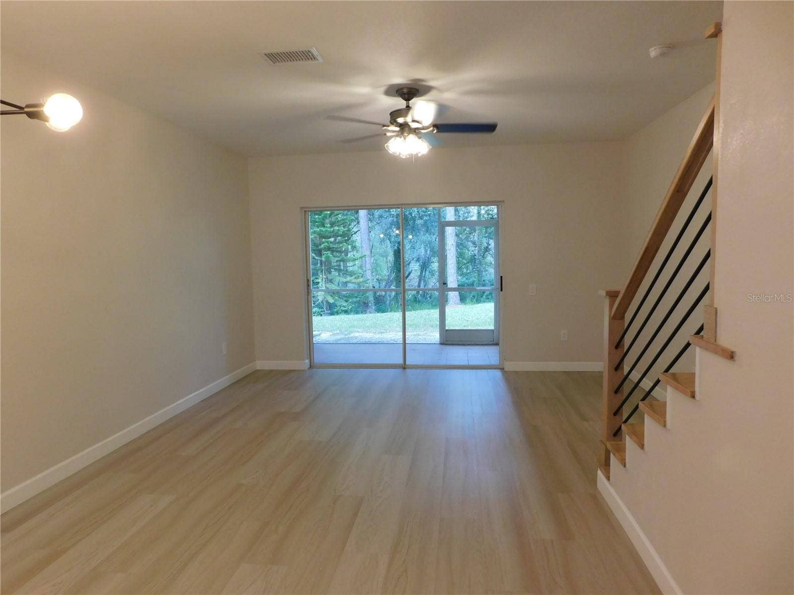 8660 HUNTERS KEY CIRCLE, Tampa, FL 33647 Living Area features new modern LVP and new Wood stairs for a modern finish