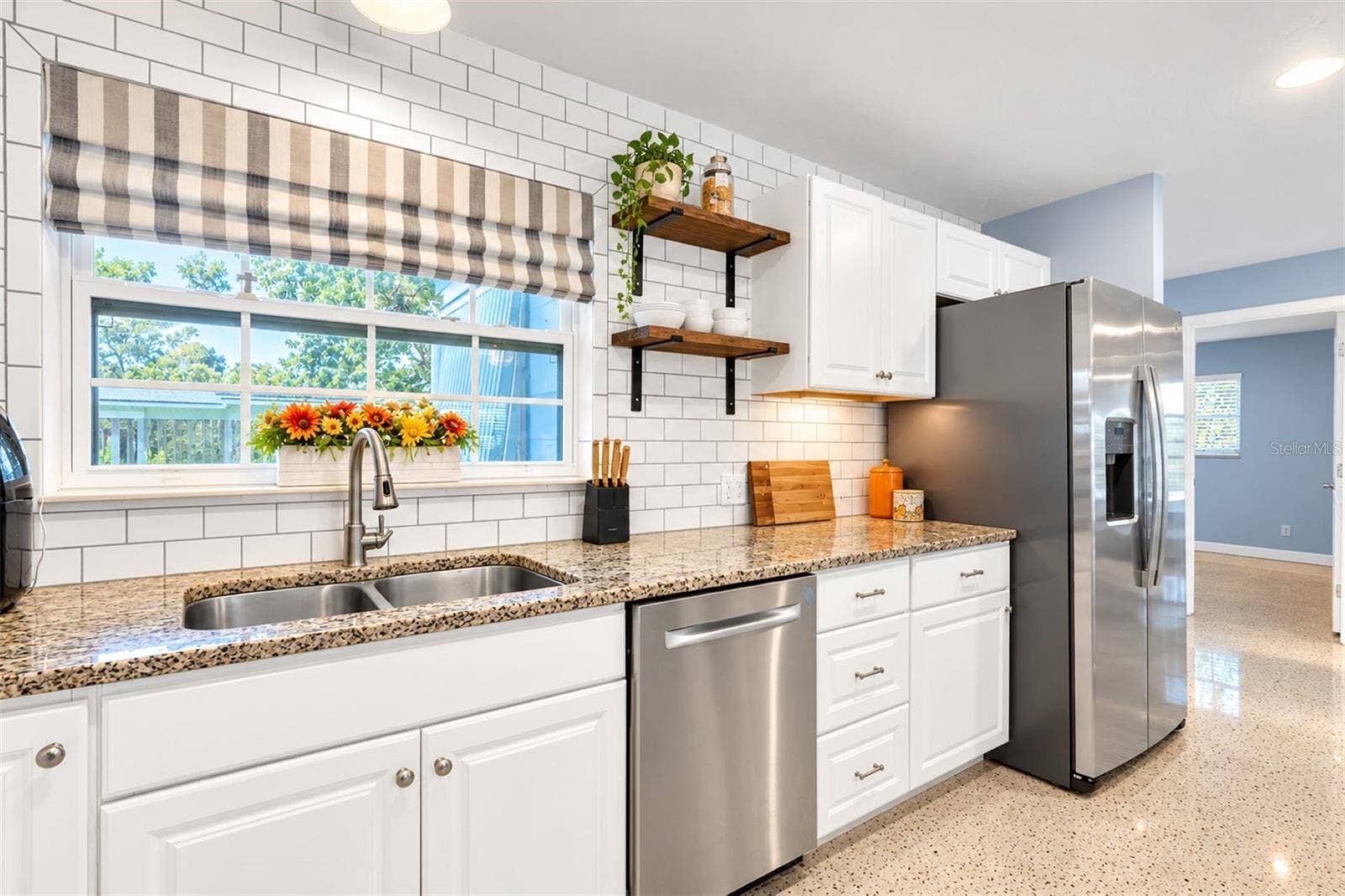5701 6TH WAY S, St Petersburg, FL 33705 Convenient pass-through window connects the kitchen to the patio. Free floating shelves add character to the farmhouse kitchen.