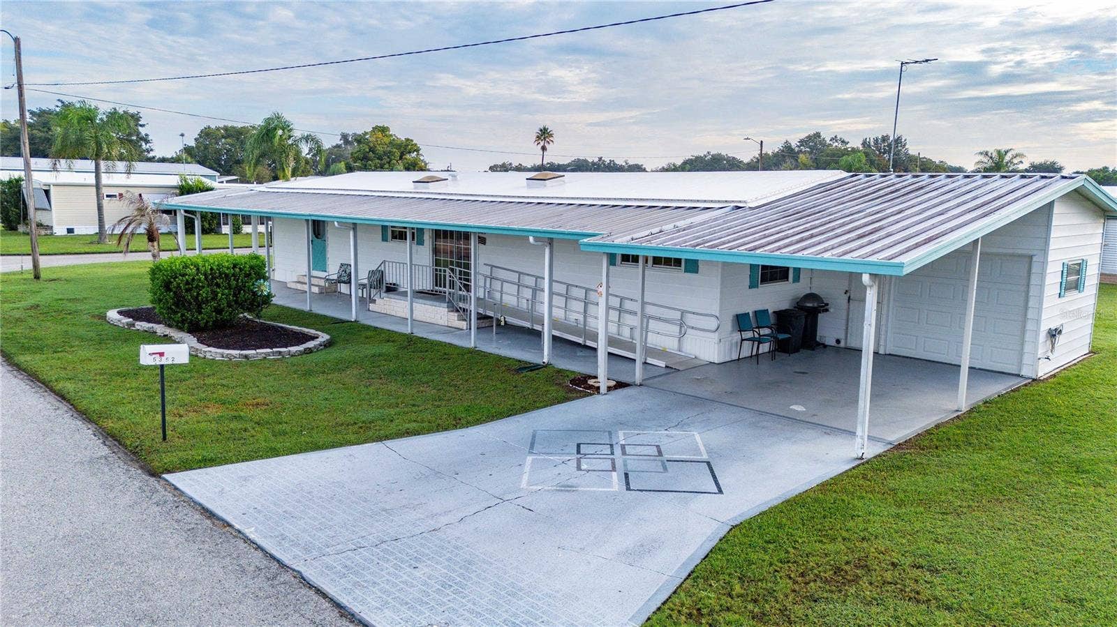5352 PLANT STREET, Zephyrhills, FL 33542 Wide carport with painted driveway.