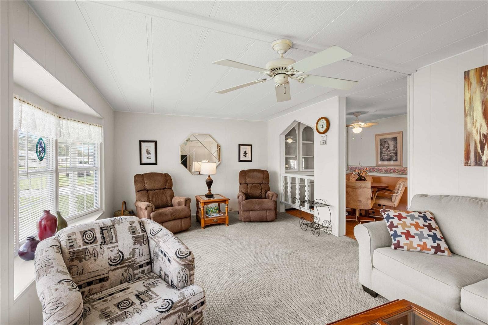 5352 PLANT STREET, Zephyrhills, FL 33542 Living room has many double pane windows.