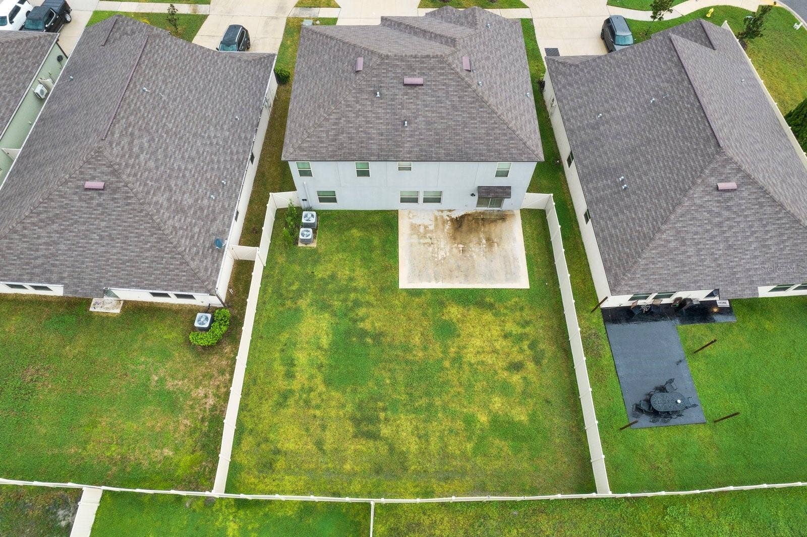 Fully fenced in backyard with concrete slab
