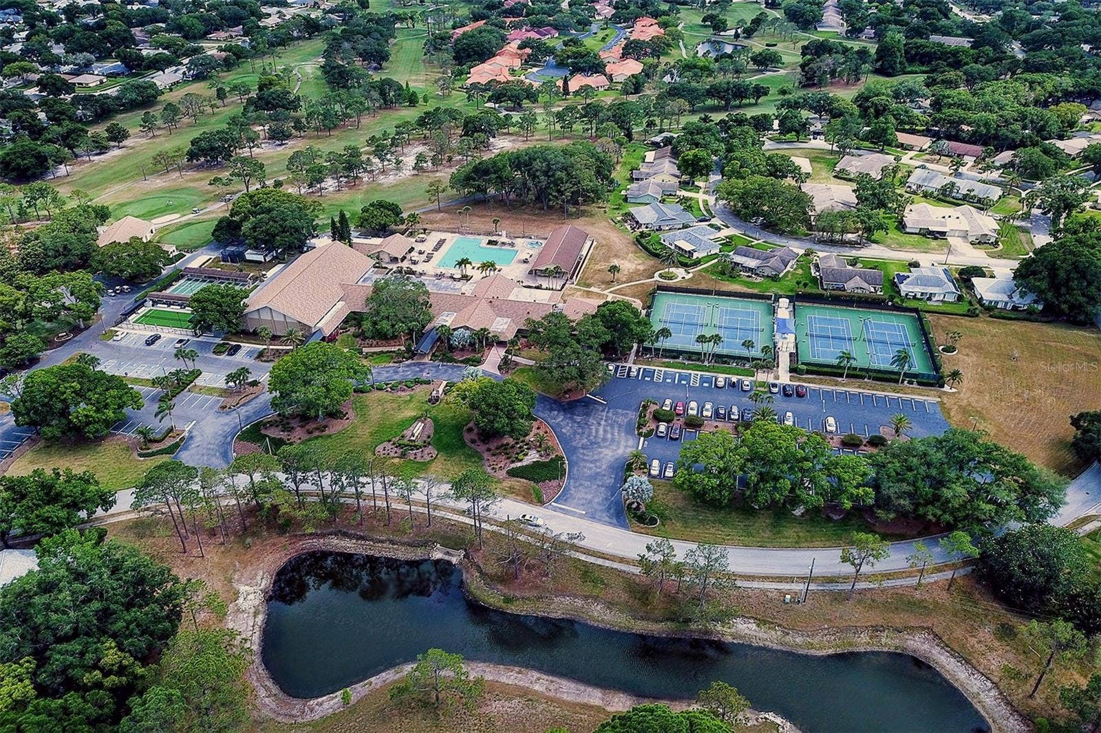 Aerial view of the golf club on the left, the main clubhouse and the tennis courts to the right