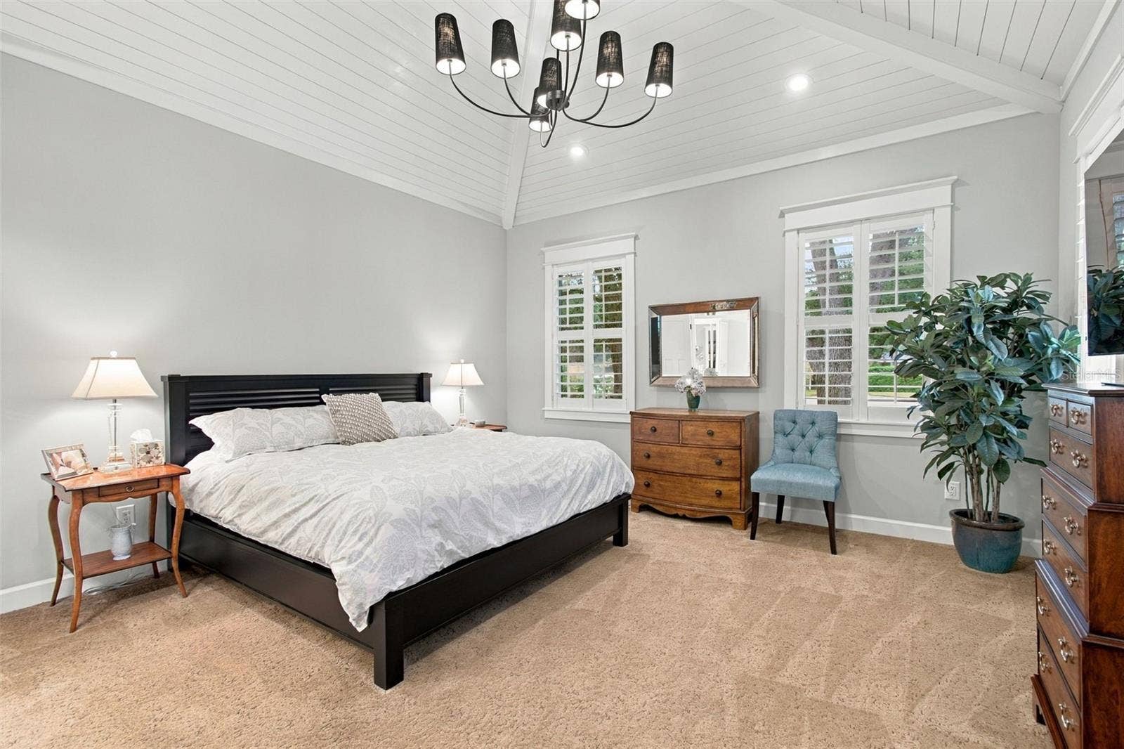 First flood Primary Bedroom with beautiful valuted ceiling with custom wood details..