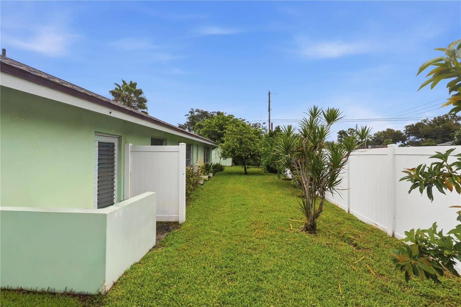 10211 139TH STREET, Largo, FL 33774 side yard with fruit trees and garage access door