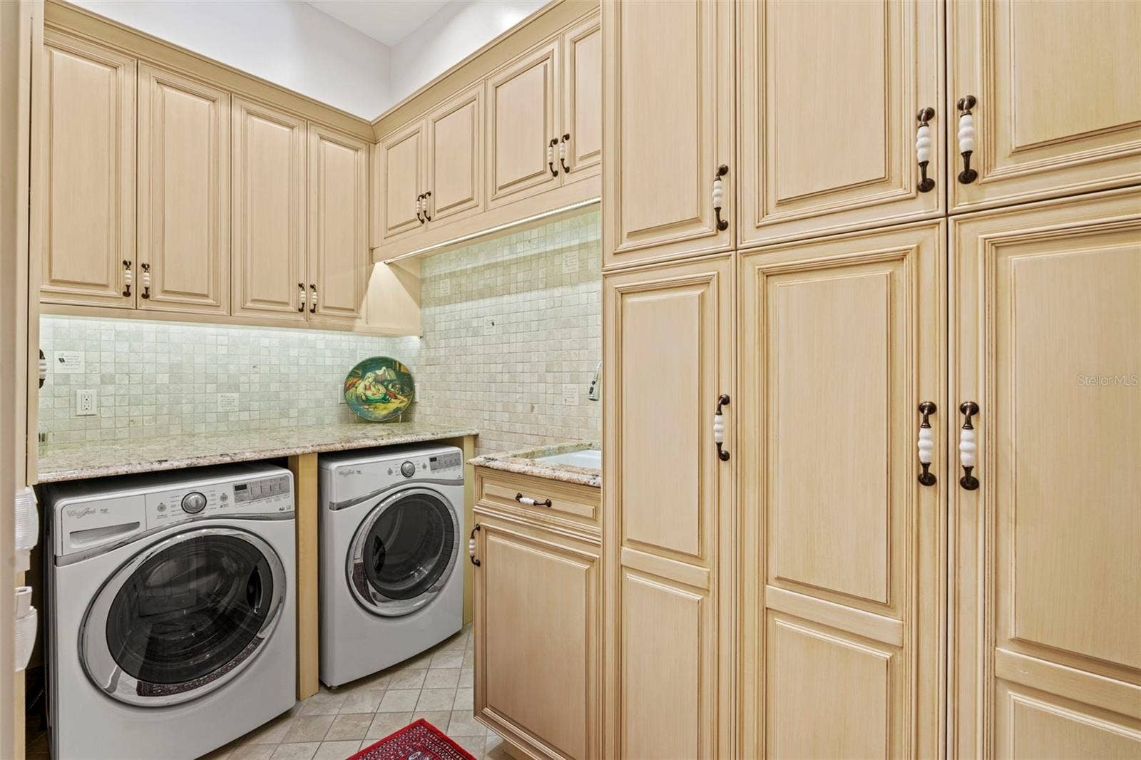 964 MONTE CRISTO BOULEVARD, Tierra Verde, FL 33715 Laundry Room with sink and plenty of custom storage cabinets for cleaning supplies and paper goods.